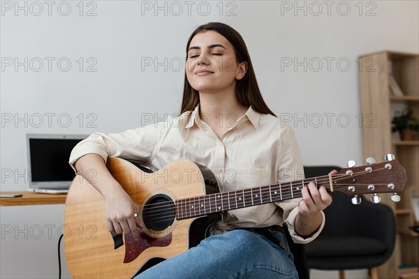 Smiley female musician playing acoustic guitar