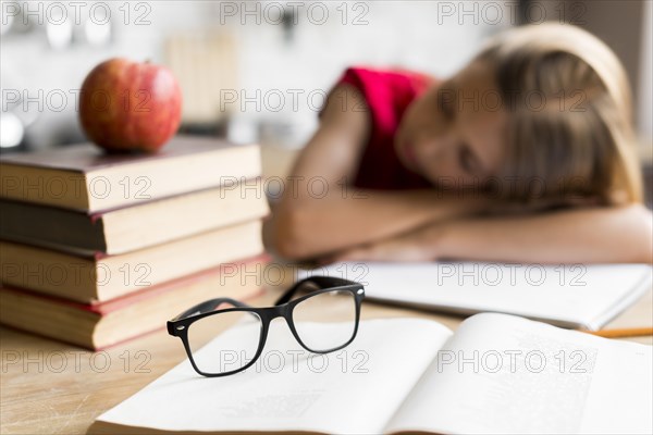 Tired schoolgirl sleeping desk