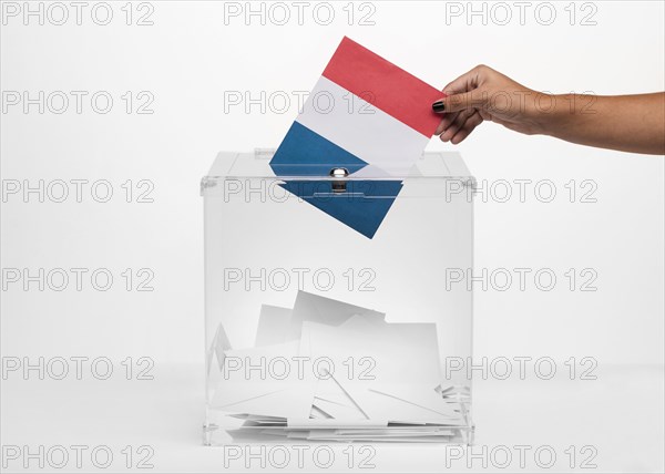 Person putting france flag card into ballot box