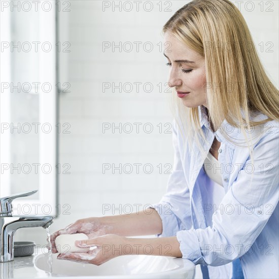 Side view woman washing her hands with bar soap