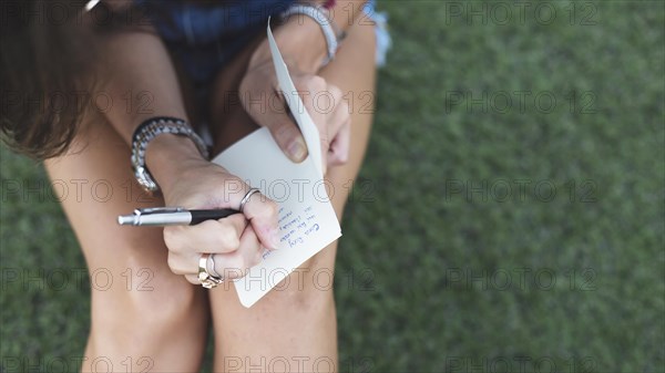 Young woman writing message paper with pen
