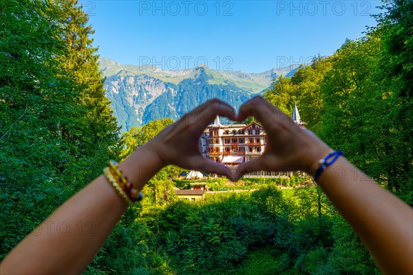 Woman Making a Heart Shape in Front of The Historical Grandhotel Giessbach on the Mountain Side in Brienz