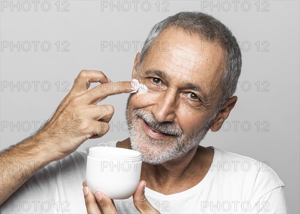 Close up man using face cream