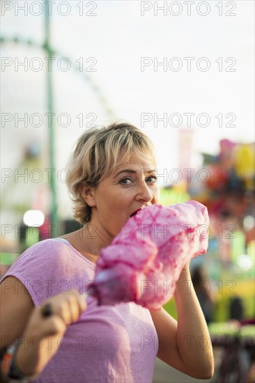 Medium shot woman eating cotton candy