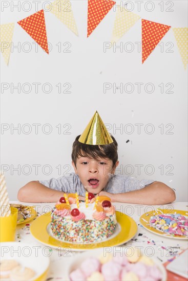 Birthday boy blowing out candles cake