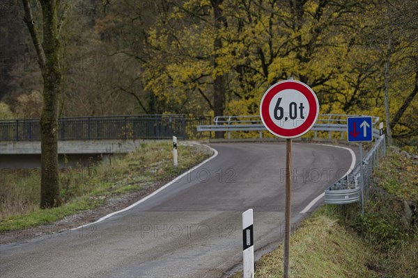 Signs with traffic regulations for weight restriction and right of way on bridge with narrow road width