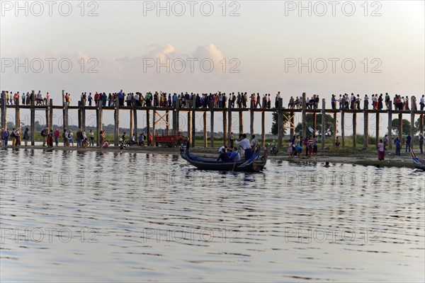 Locals and tourists on a teak bridge