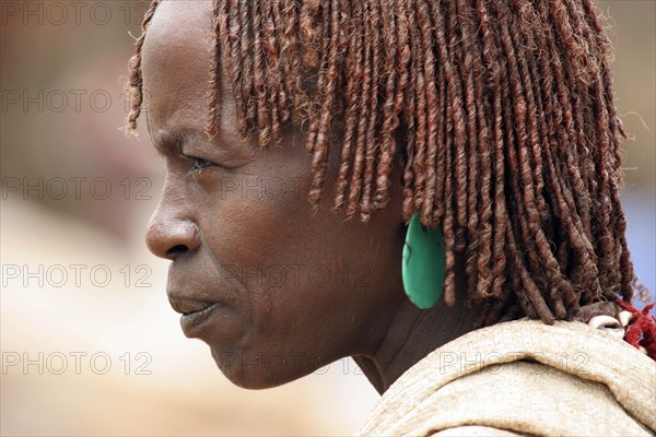 Close up portrait of woman of the Hamar tribe with traditional red headdress