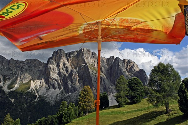 Orange sunshade and view over the mountain range Sass Rigais