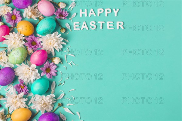 Happy easter title near bright eggs flower buds