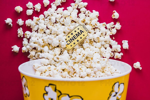 Tasty popcorn with cinema ticket