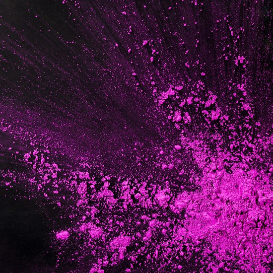 Pink dust particles splash against black background