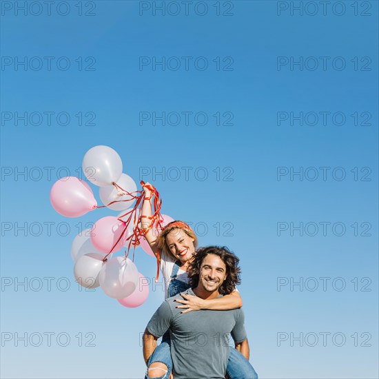 Woman with balloons back man