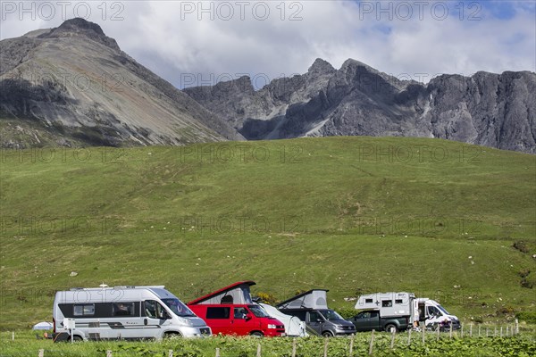 Motorhomes on camping at the foot of the Black Cuillin mountain range in Glen Brittle on the Isle of Skye