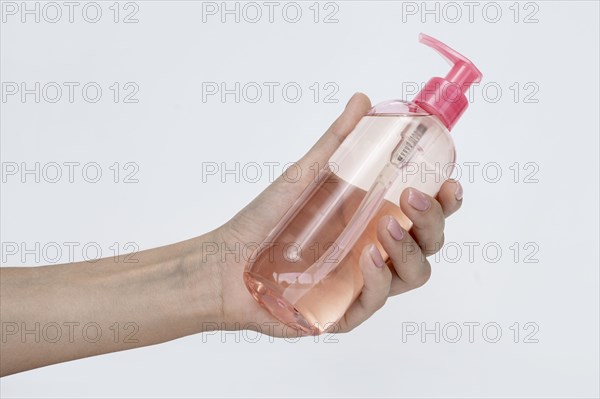 Side view person holding bottle liquid soap
