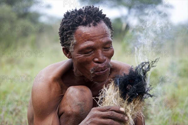 Bushman making fire in the Kalahari desert near Ghanzi