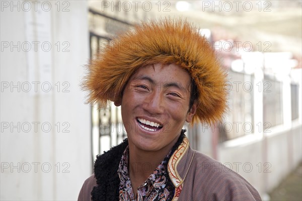 Close up portrait of smiling Tibetan man with fur hat in the village Qagca