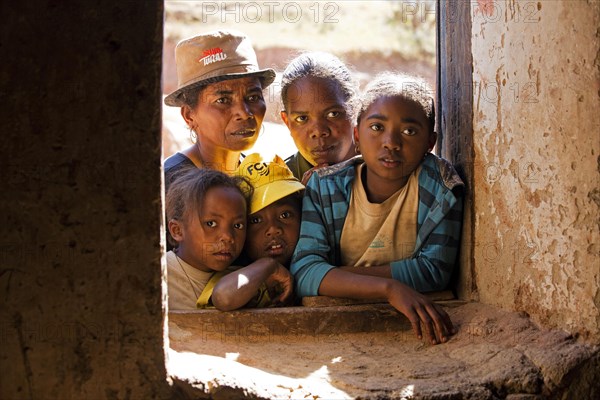 Curious Betsileo people staring through window into house