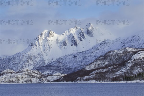 Snow covered mountains along the fjord Raftsund in winter