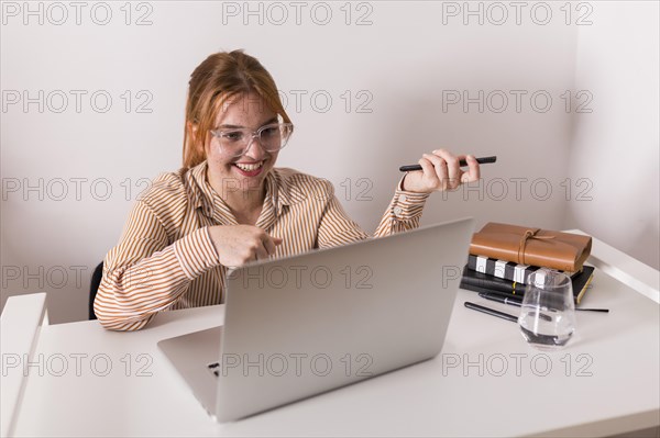 Smiley female teacher using laptop during online class with students