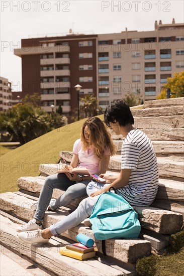 Teenagers studying together stairs street