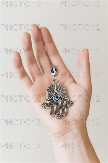 Hand holding hamsa pendant