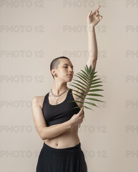 Medium shot woman posing with plant