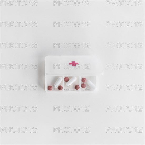 Overhead view white plastic pill organizer white background