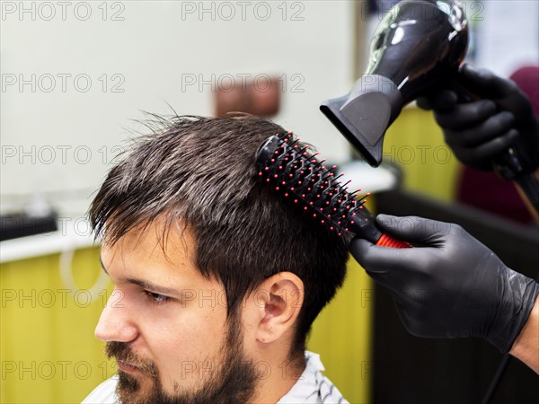 Person having his hair dried with dryer