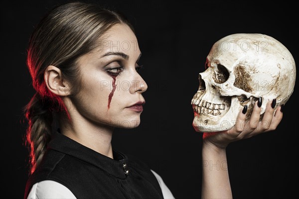 Side view woman holding skull