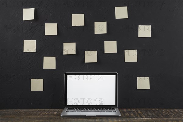 Sticky note stick black wall white blank screen laptop