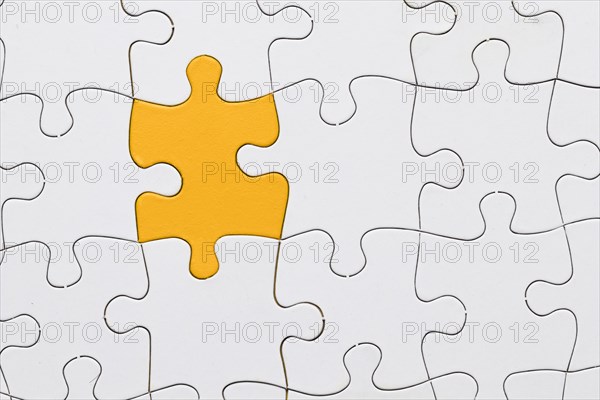 White jigsaw puzzle sheet with yellow puzzle piece center