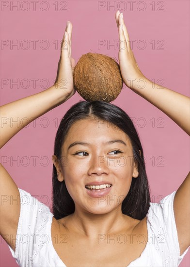 Woman holding coconut her head