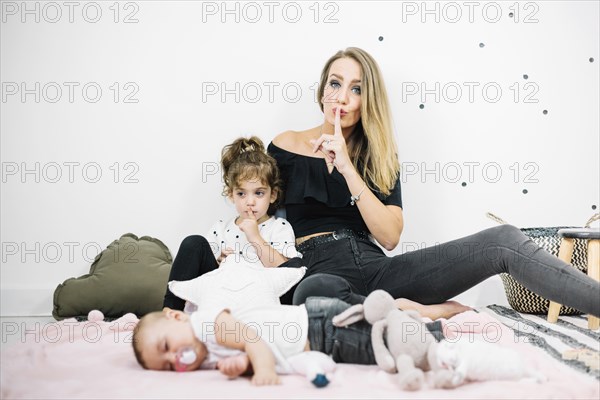 Woman making silence gesture near baby