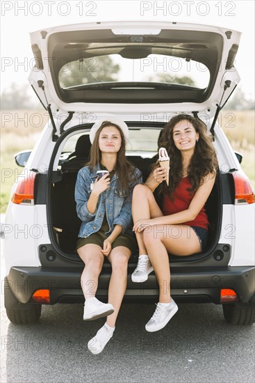 Women sitting car with ice cream