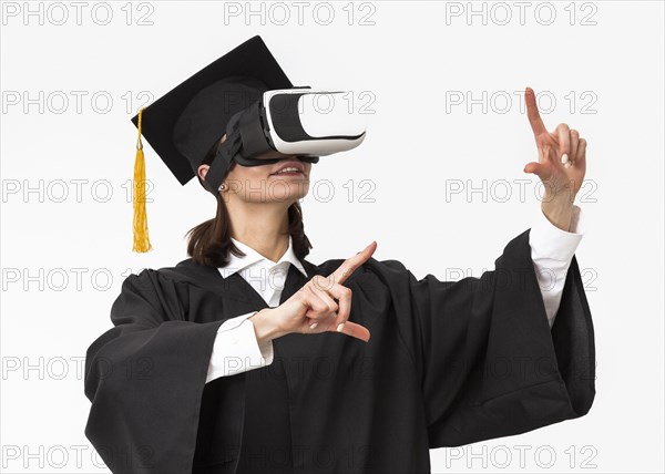 Woman with graduation robe cap wearing virtual reality headset_3