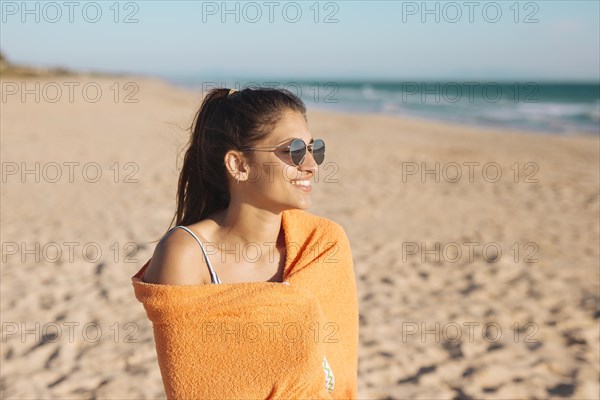 Young woman with towel sandy beach