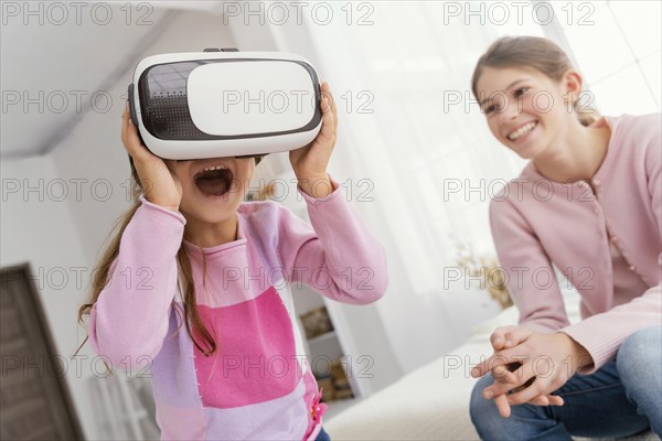 Two sisters home playing with virtual reality headset