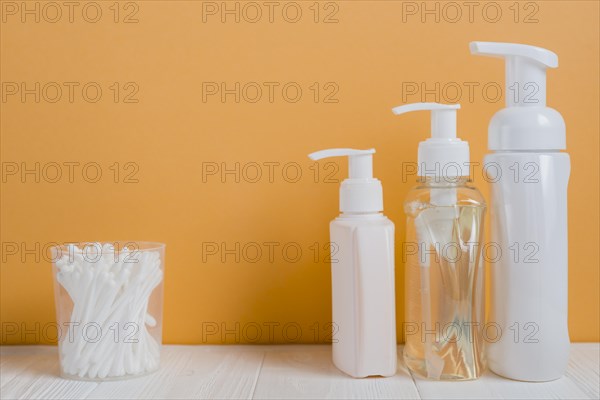 White ear buds with soap dispenser bottles white table