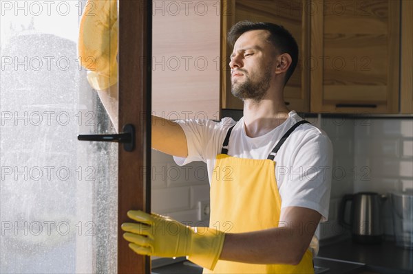 Medium shot man cleaning window