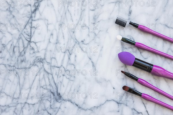 Pink make up brushes marble textured backdrop