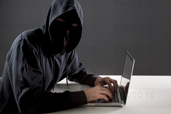Side view male hacker with laptop