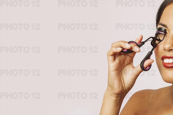 Modern woman using eyelash curler