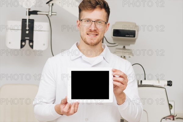 Portrait male optometrist presenting tablet template