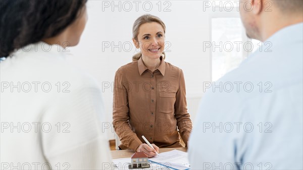 Smiley realtor signing contract new house with couple