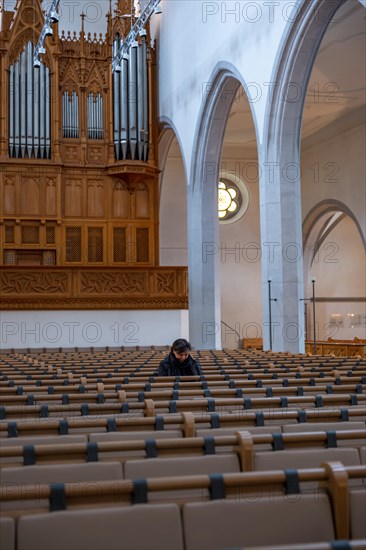 Woman Sitting Alone and Praying in St. Johann Reformed Church in Schaffhausen