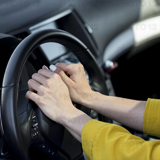 Woman resting her hands steering wheel