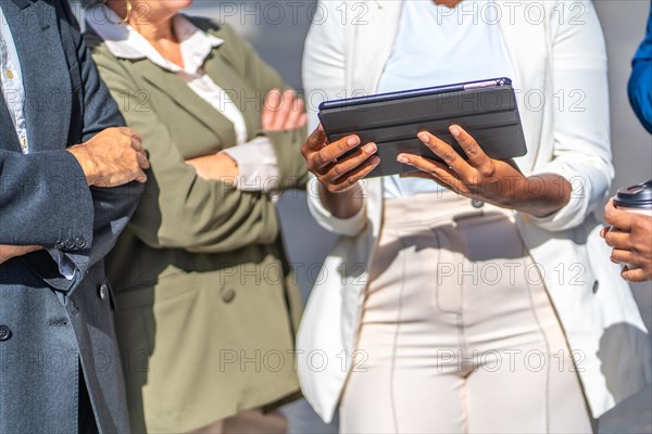 Close-up of an unrecognizable businesswoman using tablet in an outdoor meeting