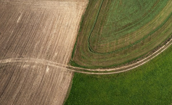 Drone view of green and ploughed fields with field path near Pabneukirchen