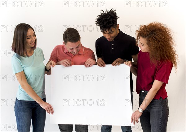 Group smiling multiethnic friends holding blank white placard standing white background